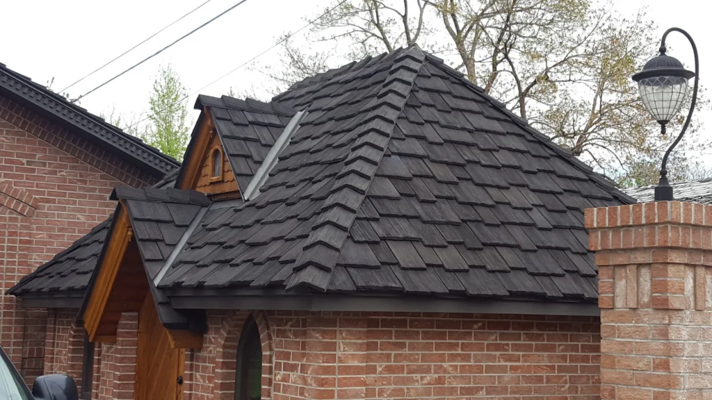 Brick home with dark cedar shake roof.
