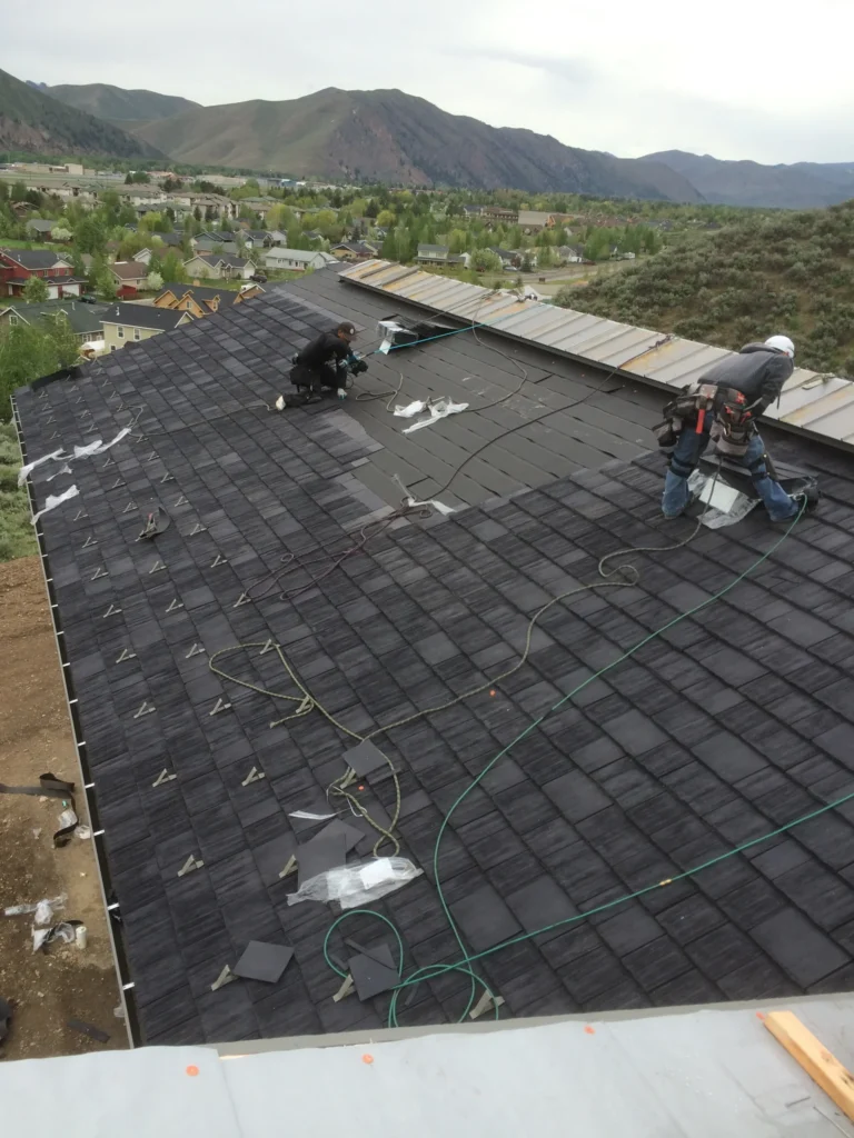 Roofing crew on top of wind resistant synthetic composite faux cedar shake shingles.