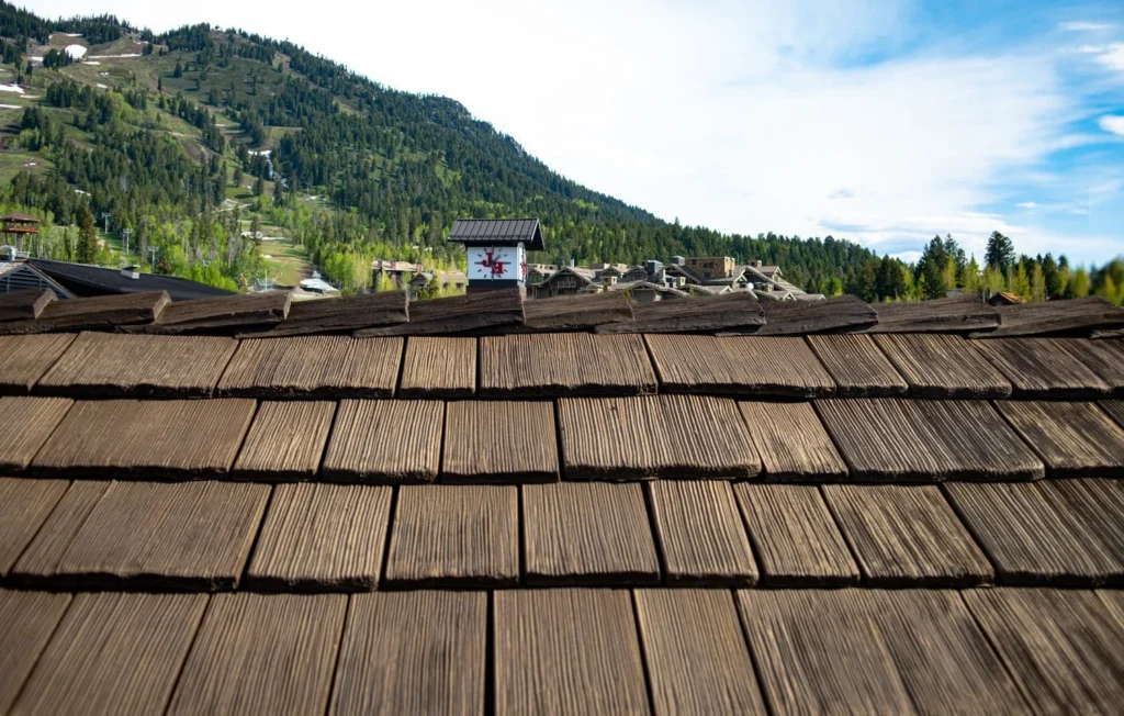 Close-up of synthetic cedar shake roofing with mountain resort views in the background.