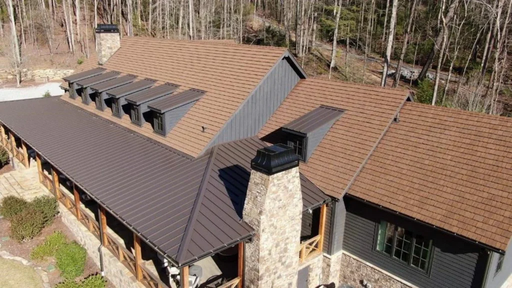 Custom home in the woods featuring a shake roof.