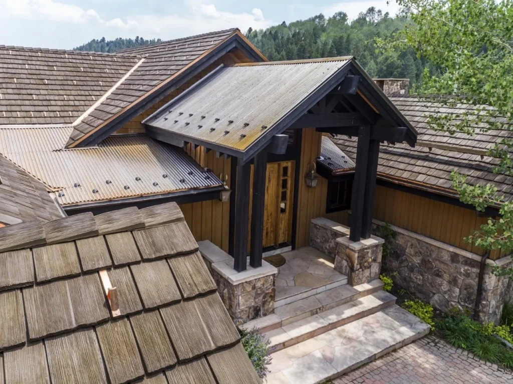 A home in the mountains with a metal roof. 