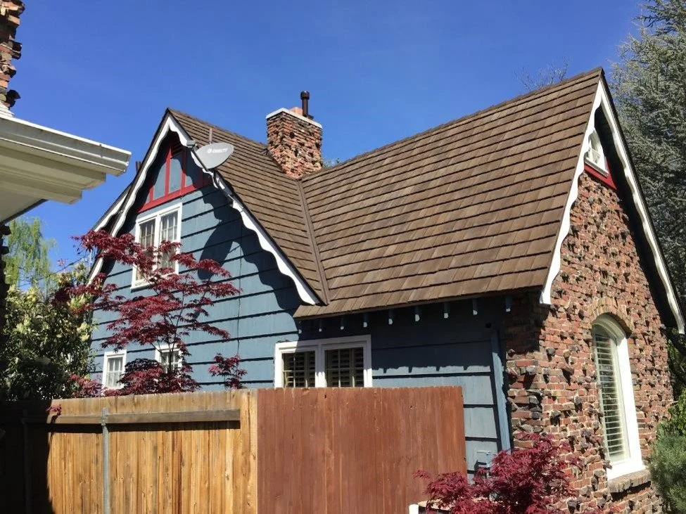 A Gable roof on a stone and siding house.