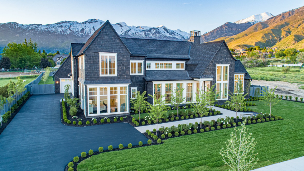 Home with dark shingle roof in snowy mountain setting.