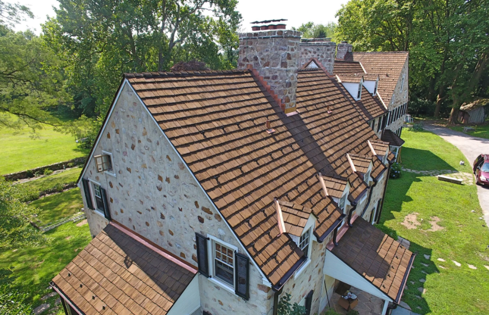 Gable roof home with composite shake roofing and stone exterior.