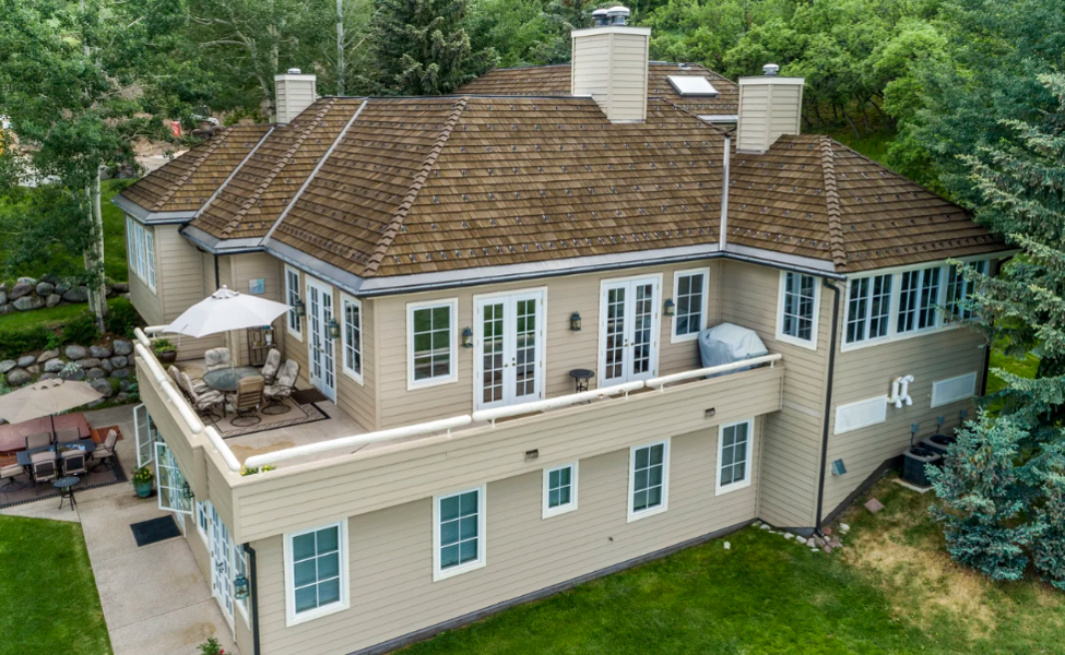 Hip roof home with composite shake roofing and multiple slopes.