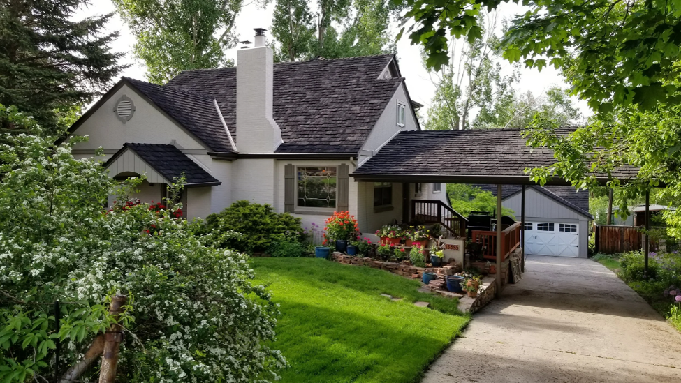 Home with a CEDUR Shiloh synthetic shake roof surrounded by lush landscaping.